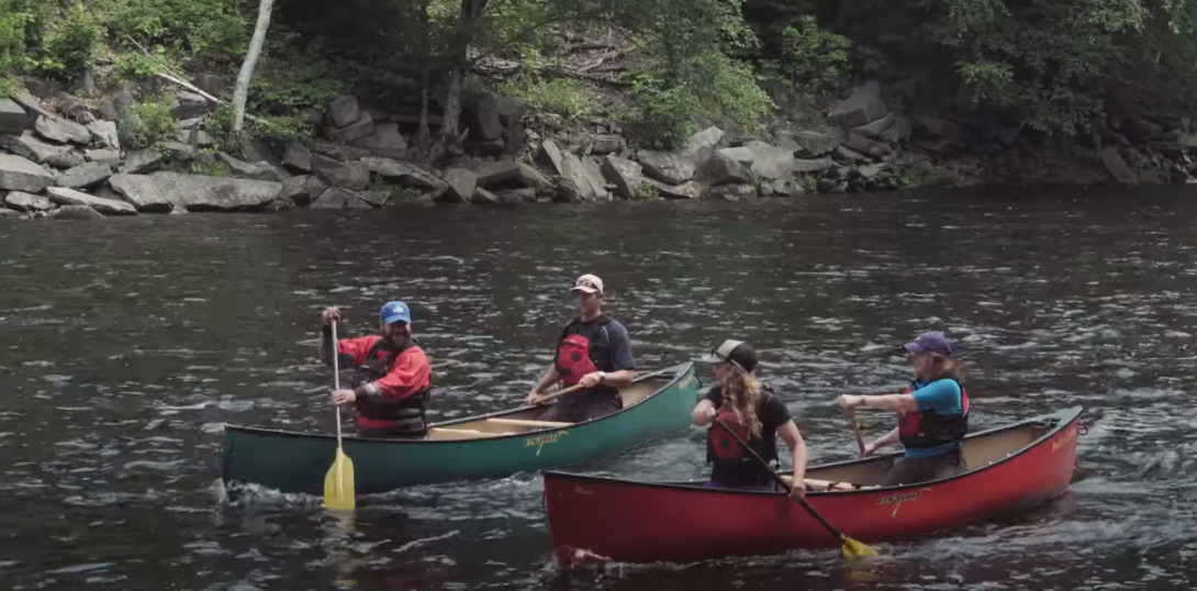 Two canoes on the river, each with two people