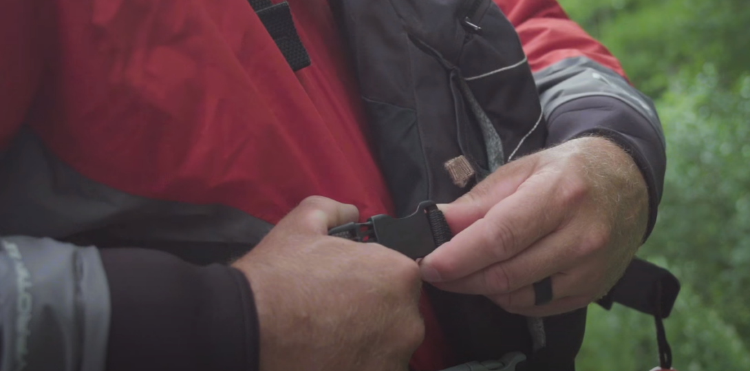 Person with closed-up view on hand, wearing a life vest